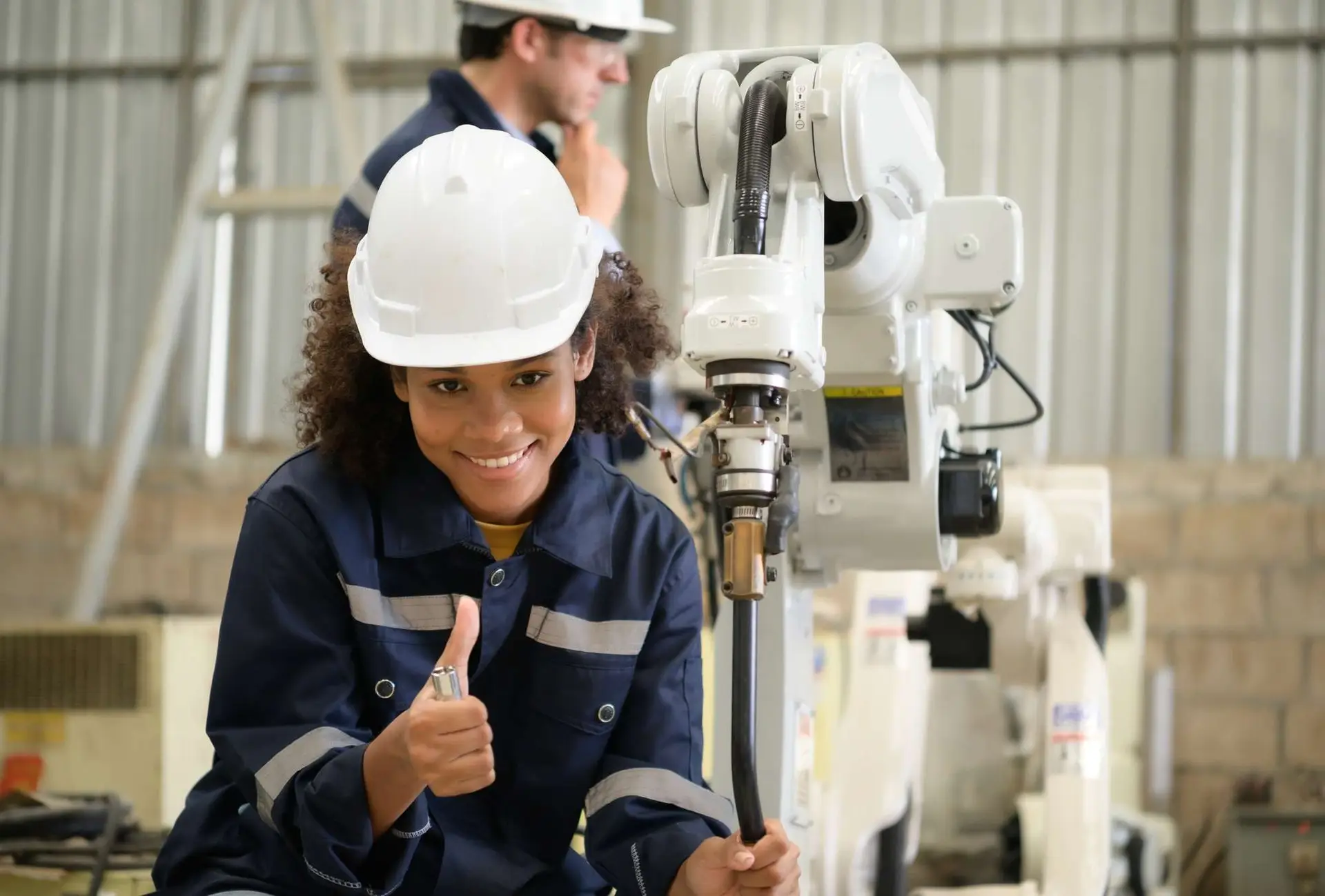 The two engineers check the operation of welding robots.